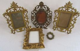 Cast metal picture frames with hinged stands and a wooden gilded frame with cherubs design