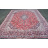 Large red ground Iranian Kashan province carpet with floral pattern 3.86m x 2.97m