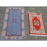 Small red Oriental inspired rug and blue and white rug with central medallion, 146cm x 80cm