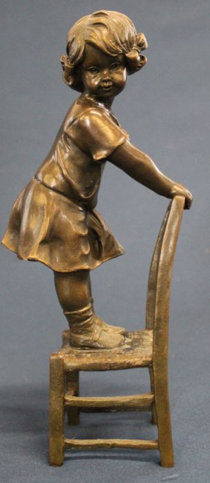 Contemporary bronze figure of a child standing on a chair signed "Nick" 20cm high