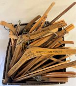 Box of wooden coat hangers, including some branded