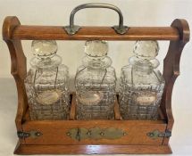 Oak tantalus with decanters bearing Birmingham W I Broadway & Co silver labels