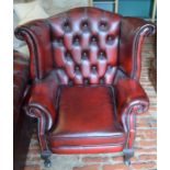 Leather wing back armchair in oxblood red leather made by Winchester Furniture