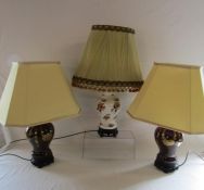 Pair of ceramic table lamps on Oriental wooden stands and one other of the same design (not tested)