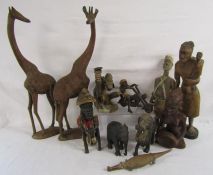 Collection of wooden figures includes tribal, giraffe, ebonised lion and elephant, crocodile etc