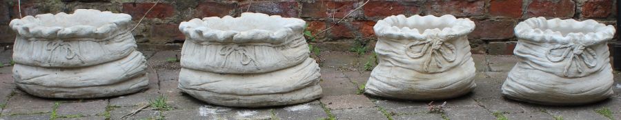2 small concrete sack shaped planters and 2 large concrete sack shaped planters