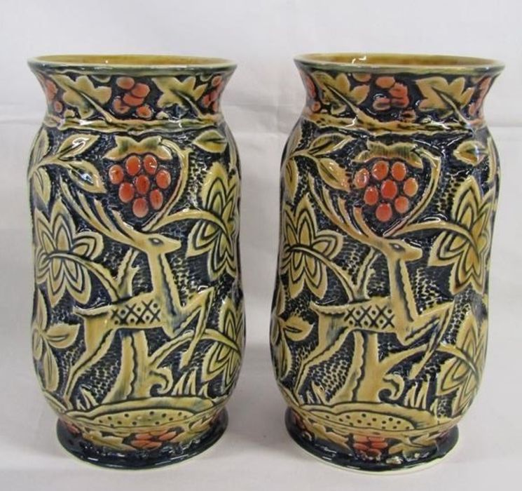 Pair of vases marked England with stag, trees and red berries design on a blue blackground - approx.