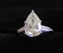 Stunning platinum ring set with central brilliant cut pear shape diamond (2.95ct) J-K in colour,