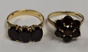 18ct garnet 3 stone band ring, total weight 4.5g, size O and 9ct garnet daisy ring, total weight 3.