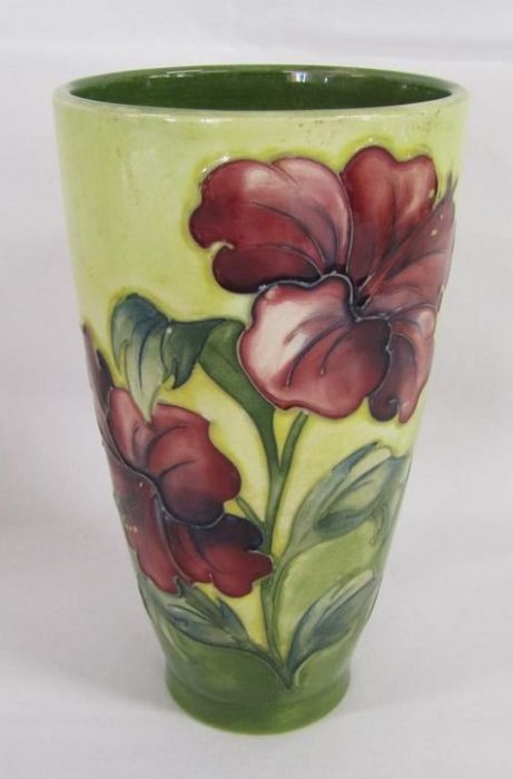 Moorcroft tapered vase with wider top bearing hibiscus design on yellow background with green