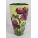 Moorcroft tapered vase with wider top bearing hibiscus design on yellow background with green