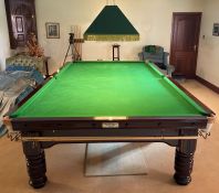 Full size early to mid 20th century slate bed snooker table in mahogany with a suspended light.  The