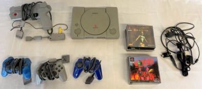 PlayStation 1 model SCPH-1002 with games including Die Hard, Tomb Raider and Worms and 4