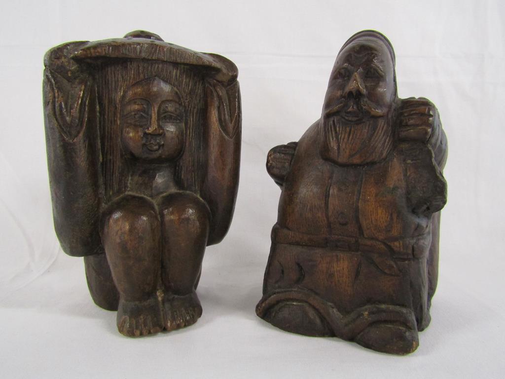 Two wooden carved figures - one possibly Santa carrying a sack and the other of a lady holding her