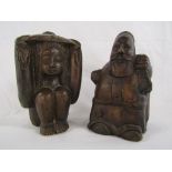 Two wooden carved figures - one possibly Santa carrying a sack and the other of a lady holding her