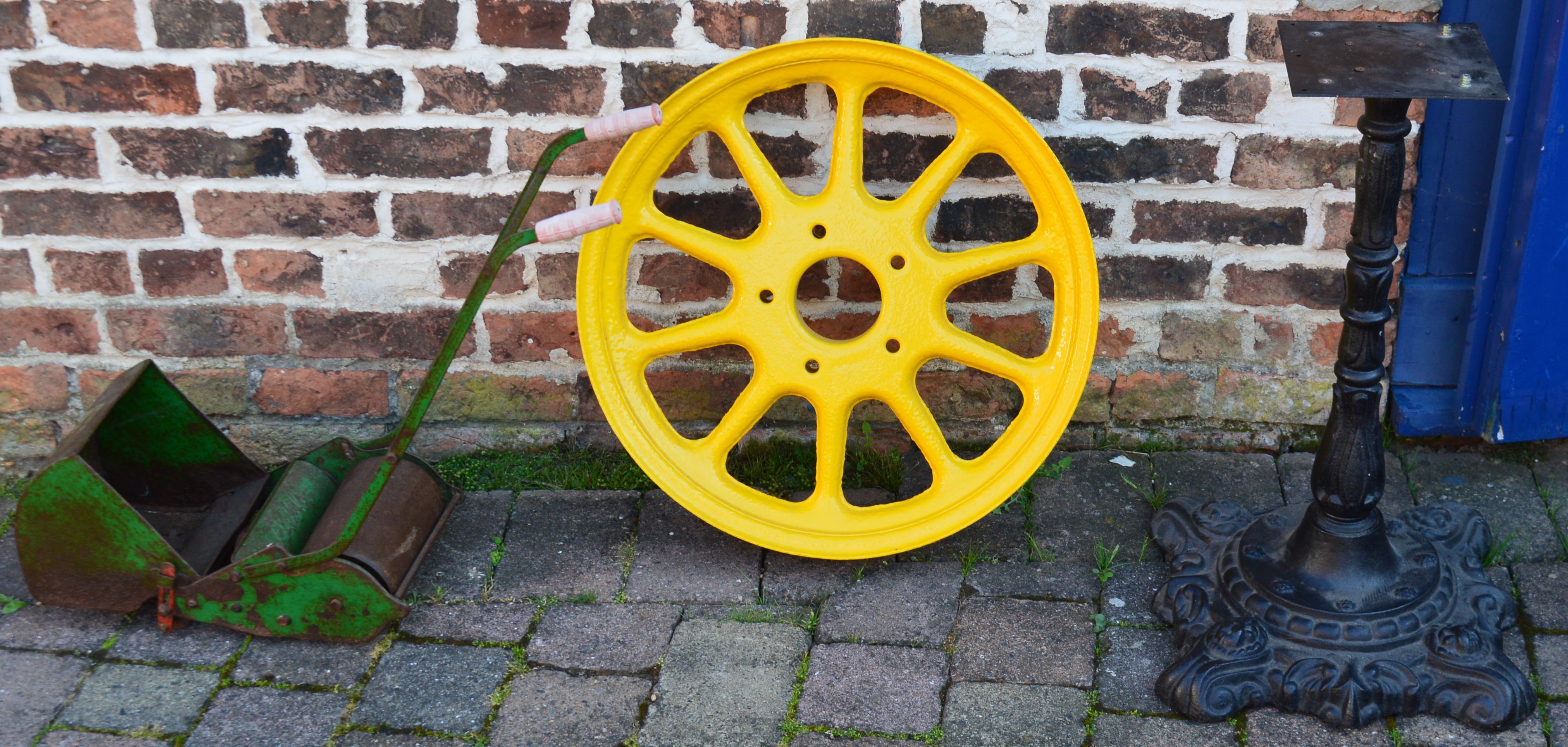 Tractor wheel, cast iron table base and child's Webb hand push lawn mower