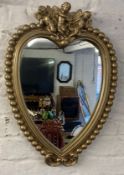 Heart shape mirror in a gold painted frame with cherubs aloft Ht 60cm X 43cm
