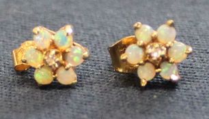 Pair of 14k gold & opal flower stud earrings with central diamond chip, 1.6g