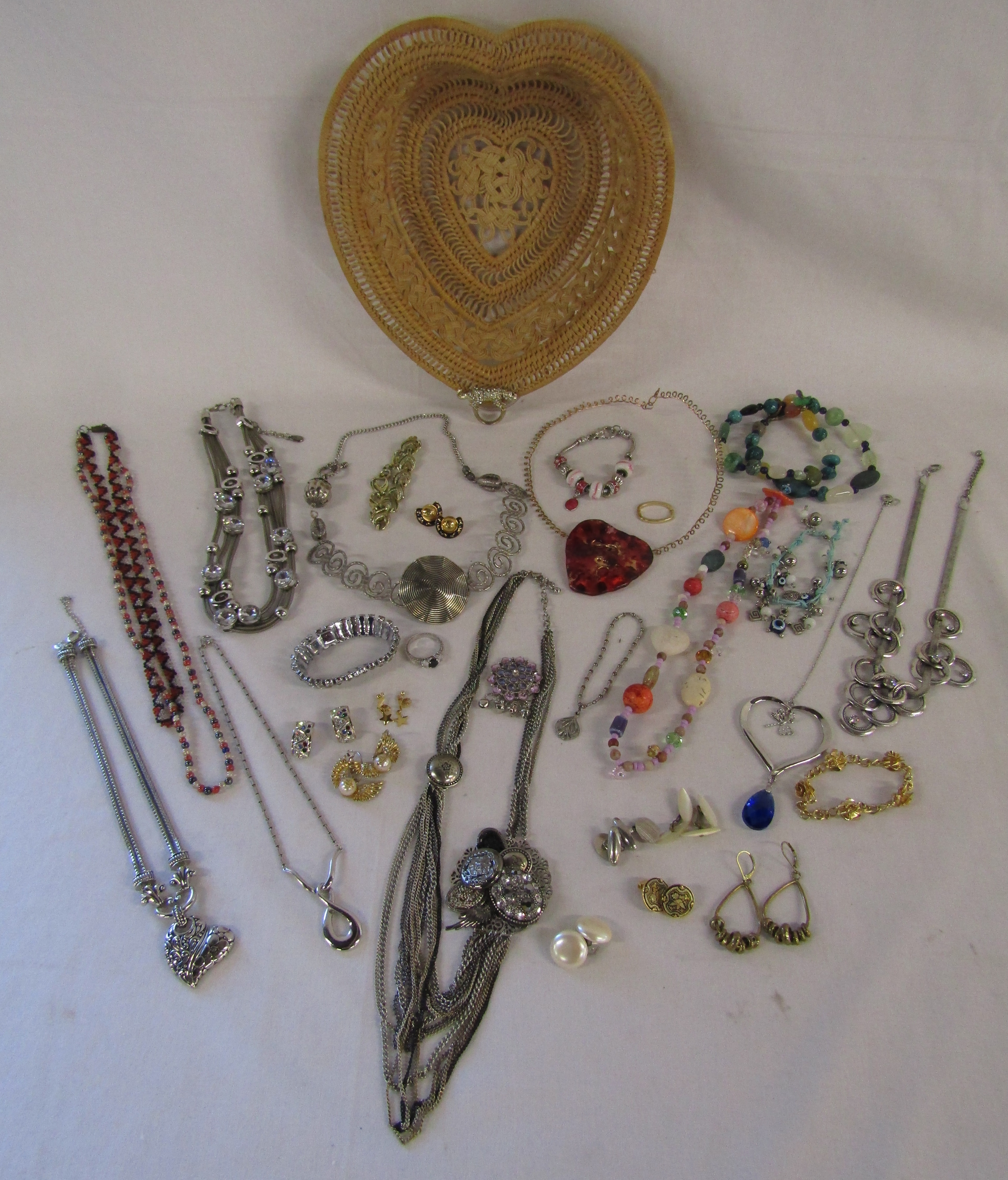 Selection of costume jewellery in a heart shaped wicker basket