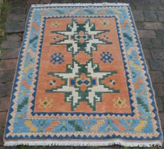 Red ground wool rug with blue border 128 x 192cm