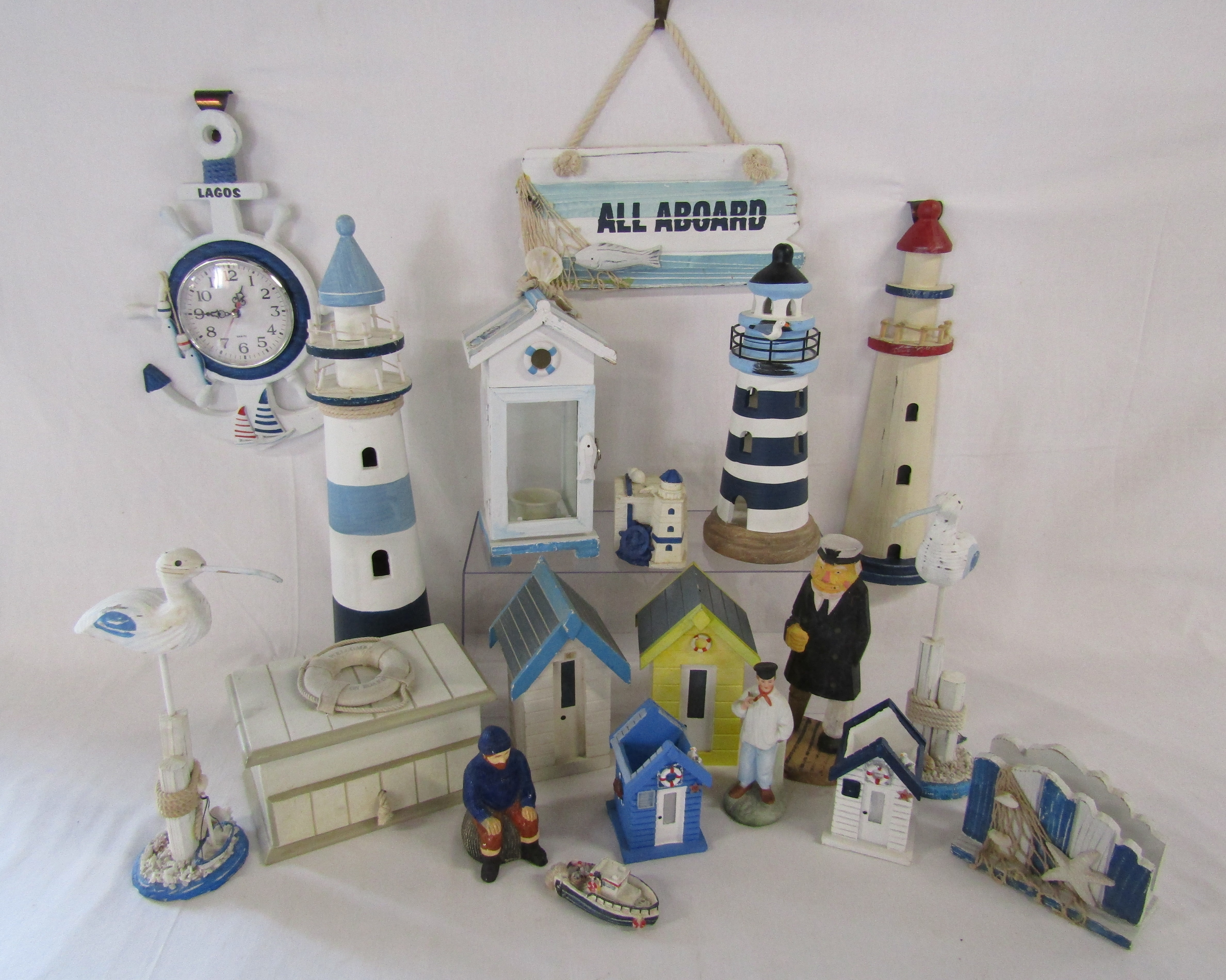 Collection of wooden beach ornaments includes, clock, lighthouses, beach hut money boxes, candle
