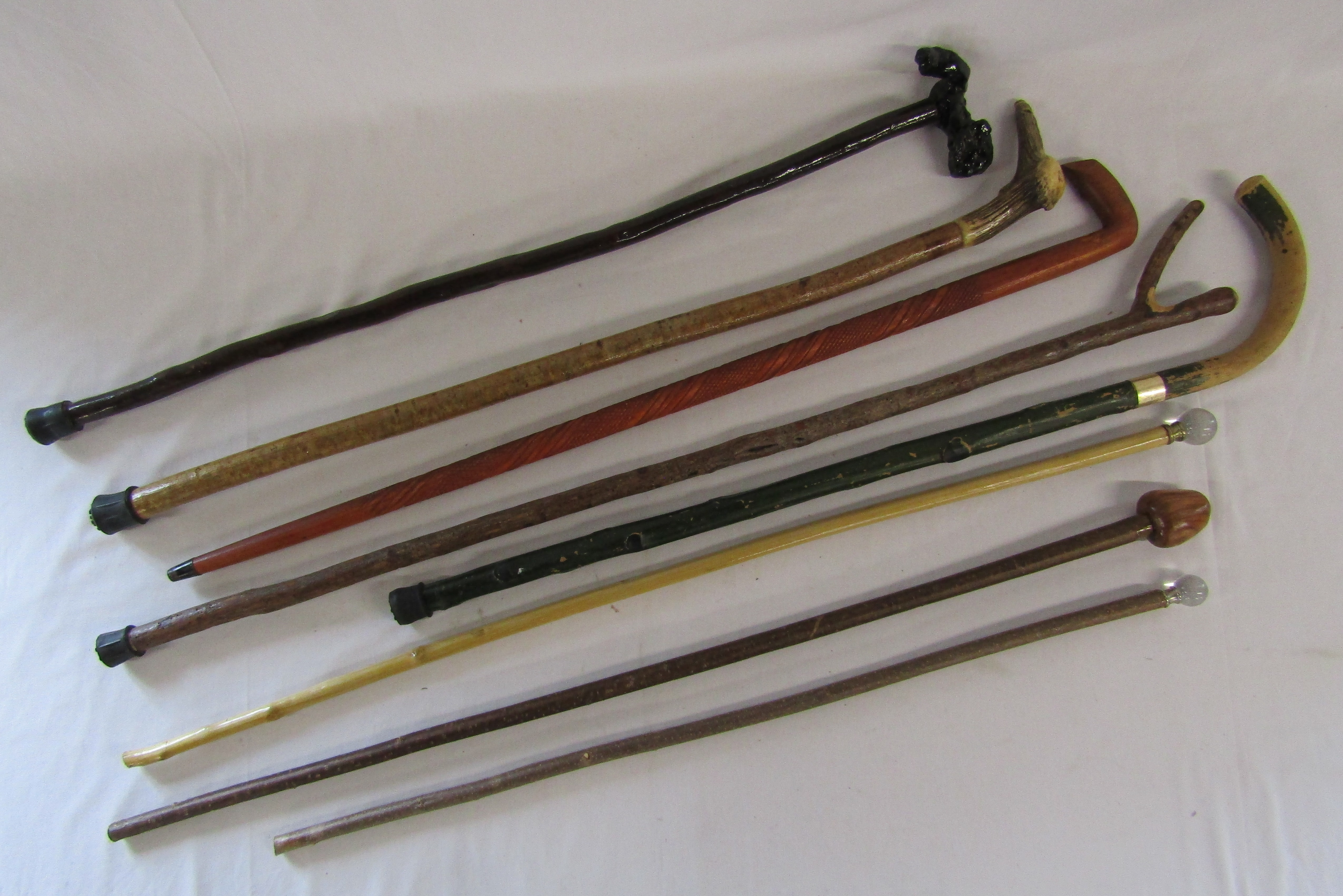 Collection of walking sticks includes Harrods, horn handle, gnarly wood handle etc