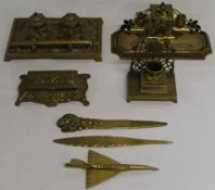 Various brass items, including inkwells, model quill, clown letter opener and plane