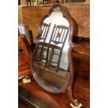 A late 19th century caved walnut framed pear-shape easel mirror, on splay supports, 21" wide x 26"