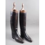 A pair of leather riding boots with shoe lasts