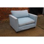 A pair of "Snuggler" two-seat settees, upholstered in a pale blue fabric, 52" wide x 27" deep x
