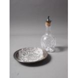 A cut glass butter dish with silver tray and a cut glass oil jar with silver pourer
