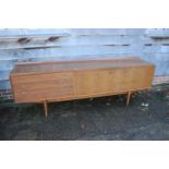 A 1960s Archie Shine teak sideboard, fitted four drawers with reeded fronts and cupboards and
