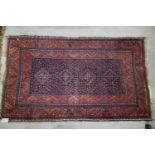 A Bokhara type rug with four stepped medallions on a blue ground with geometric borders in shades of