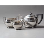 A silver three-piece teaset with engraved band decoration, 29oz troy approx