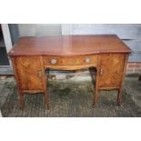 A mahogany break bowfront sideboard, fitted two cupboards and centre drawer, on splay supports,