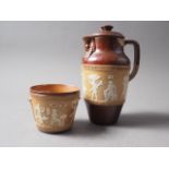 A Royal Doulton stoneware jug with relief Egyptian decoration, 9" high, a similar smaller vase and