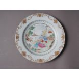 An 18th century Chinese export plate with European  figures in a garden and gilt scroll