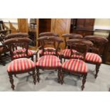 A set of seven  Victorian mahogany bar back dining chairs with carved decoration and stuffed over