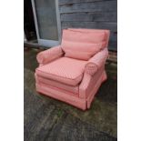 A 20th century deep low seat armchair, upholstered in a rust patterned fabric, on castored supports