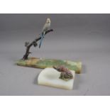 A pale green hardstone ashtray, mounted two metal red grouse, and a metal model of a parakeet, on