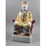 A Chinese porcelain figure of a seated mandarin, in yellow jacket, 19" high