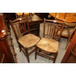 A pair of mahogany spindle back rush seat side chairs, on square taper supports (damages)