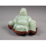 A Chinese green jade figure of Buddha, on hardwood stand, 3 1/2" overall