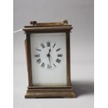 A brass cased carriage clock with white enamel dial and Roman numerals