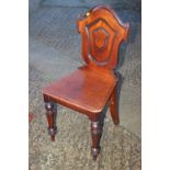 A mid 19th century carved mahogany hall chair with panel seat, on turned supports