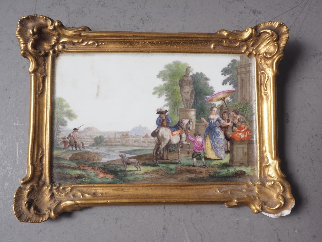 A Continental porcelain plaque, formed as a painting with figures in a landscape decoration, in gilt