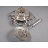 A silvered metal model of a crab and a white metal server with circular pierced bowl