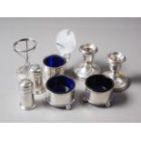 A pair of silver pepper pots, two salt cellars with blue glass liners, a mustard pot with blue glass