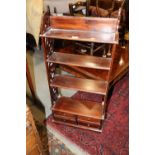 A mahogany fretwork four-tier open shelf, fitted four drawers, on bracket feet, 21" wide x 7 1/2"