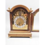 An oak cased arch topped mantel clock with silvered and gilt dial, Roman numerals, gilt finials